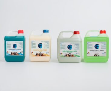 La imagen muestra cuatro productos de limpieza, destacando champú para perros.